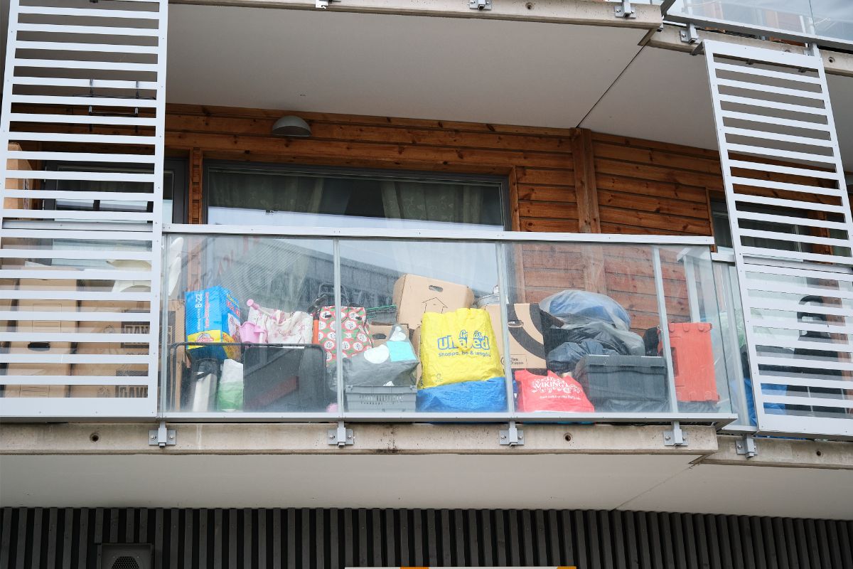 Balkón zaprataný taškami a krabicami.