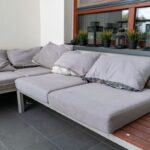 Sedačka na balkóne s natrhnutými vankúšmi, z ktorých trčí výplň.