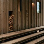 Časť domu z dreva so schodmi a výklenkom na drevo na kúrenie.