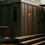 Dom z cédrového dreva so schodiskom a vstavaným výklenkom na štiepané drevo.