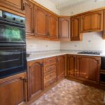 Zastaraná kuchynská linka z 90. rokov s drevenými skrinkami.