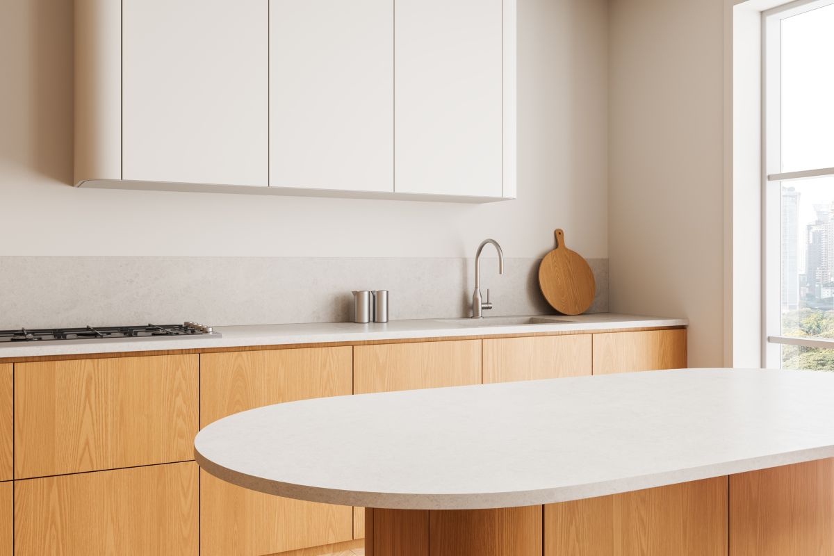 Moderná kuchynská linka v dekore medového dreva s ostrovčekom s bielou pracovnou doskou a bielymi vrchnými skrinkami.