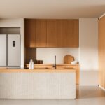 Moderná kuchynská linka v minimalistickom štýle s drevenými skrinkami vo farbe medového dreva.