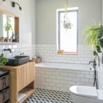 Kúpeľňa s obkladom v štýle metro, murovanou vaňou a čiernym umývadlom na drevenej skrinke.