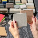 Ženské ruky držia vzorku materiálov na obklady do kúpeľne.