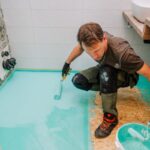 Muž pri nanášaní hydroizolácie.