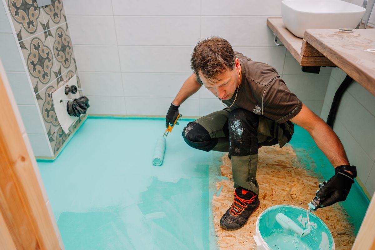 Muž pri nanášaní hydroizolácie.