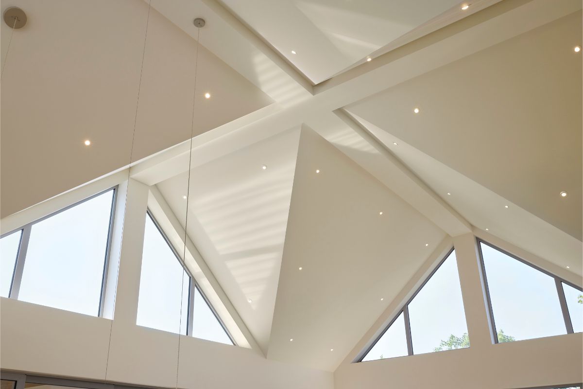 Vysoké trojuholníkové okná v štíte členitej strechy púšťajú denné svetlo aj do stredu dispozície.