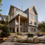 Trojpodlažný dom s kamenným obkladom a bridlicovou terasou.