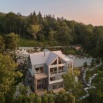 Vila s plechovou strechou v tvare kríža a kaskádovitou záhradou v lese.