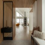 Chodba s lamelovým obkladom a svetlou podlahou.