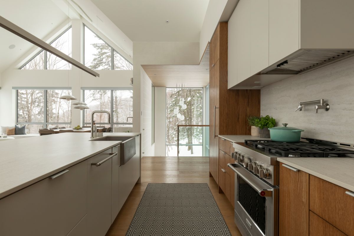 Kuchyňa s drevenými a bielymi skrinkami a bielym ostrovčekom.