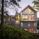 Viacpodlažná moderná novostavba so sivou kovovou kamennou fasádou a vysokými oknami.