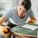 Žena premeriava rozmery starej stoličky.