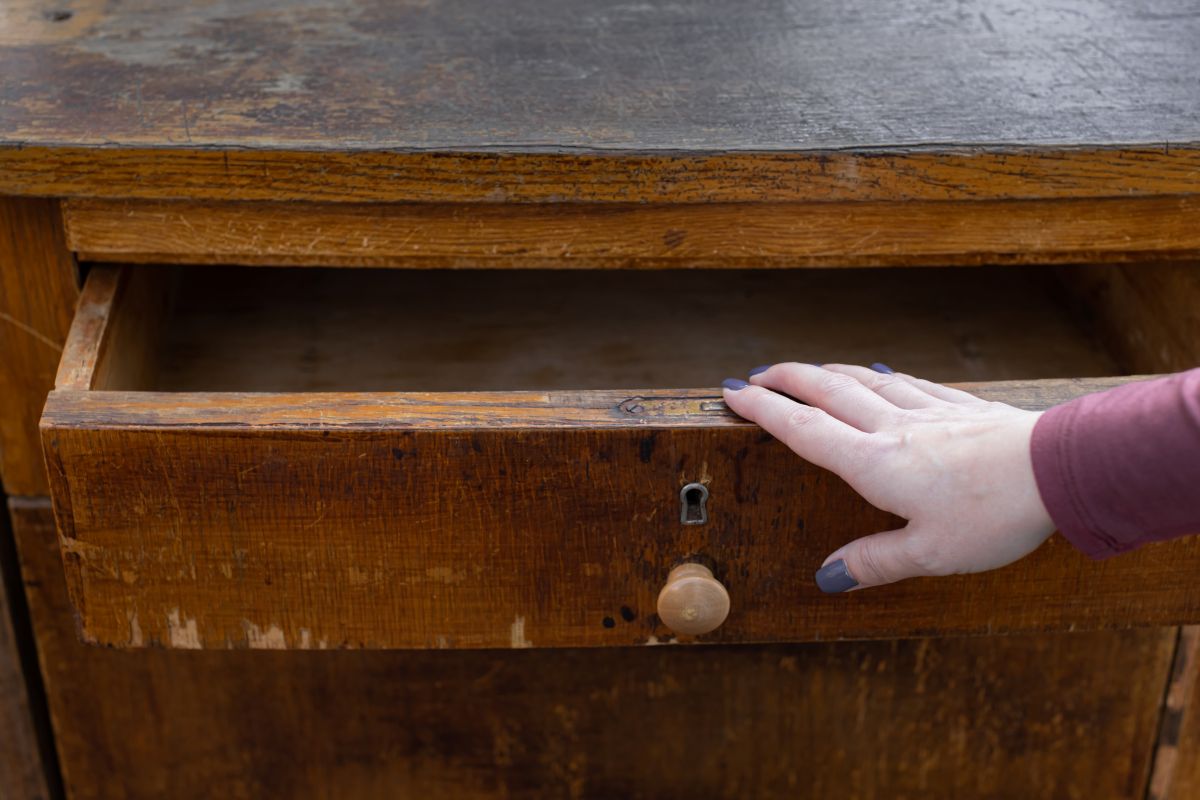 Detail na pootvorenú zásuvku starožitného bielizníka.