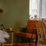 oranžové kreslo pri olivovozelenej stene s jemným odleskom.