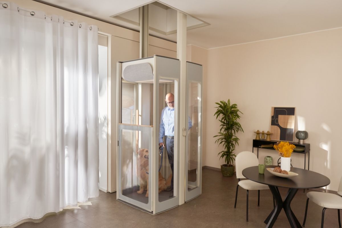 Starší muž so psom v domácom výťahu v interiéri.