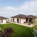 Moderný jednopodlažný dom s krytou terasou, záhradným domčekom a upraveným dvorom.