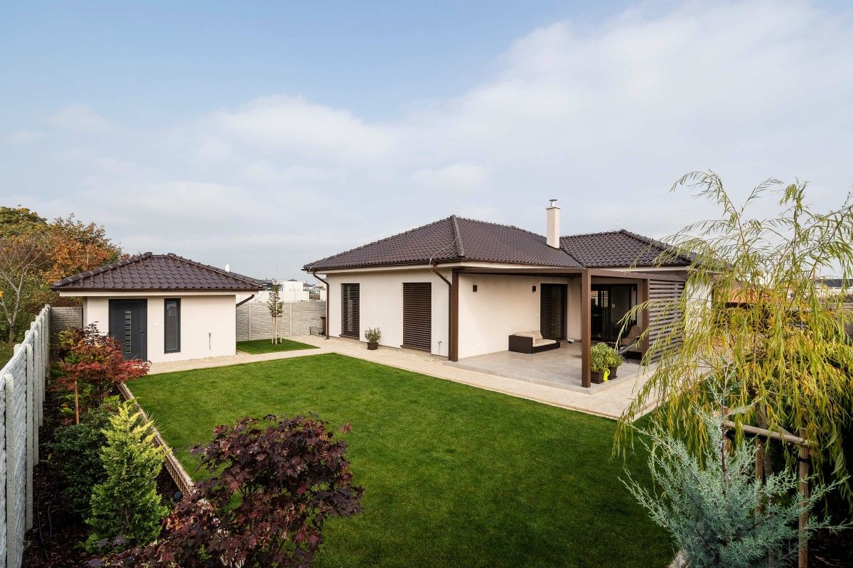 Moderný jednopodlažný dom s krytou terasou, záhradným domčekom a upraveným dvorom.