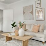 Obývacia izba s béžovou textilnou sedačkou, nízkym dreveným stolom a bielym huňatým kobercom.