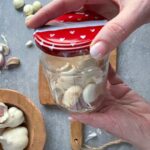 Detail na strúčiky cesnaku v sklenenom pohárom s vrchnákom.