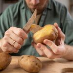 Detail na muža lúpajúceho uvarený zemiak.