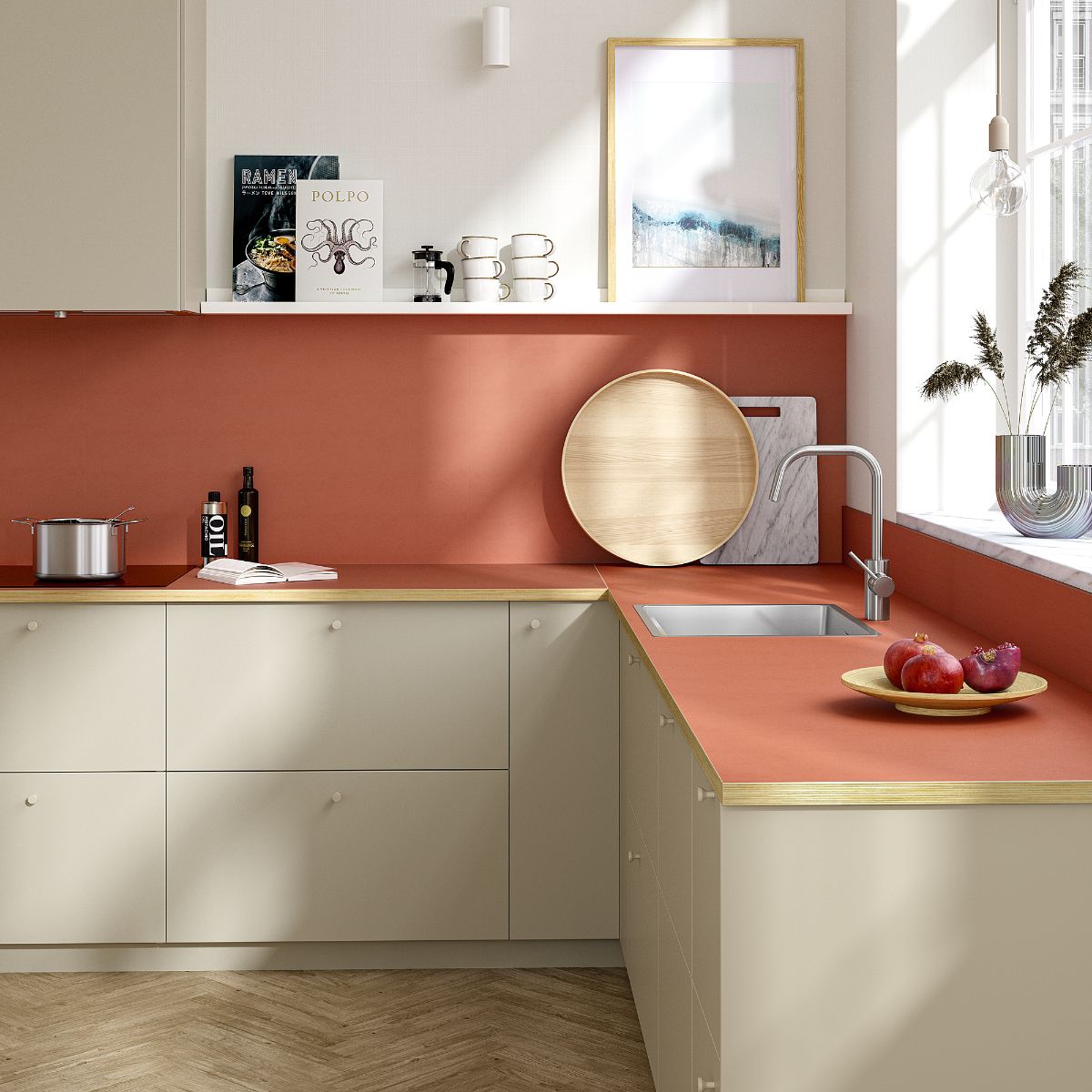 Moderná kuchyňa s terakotovým pracovným pultom, béžovými skrinkami a dubovými parketami.