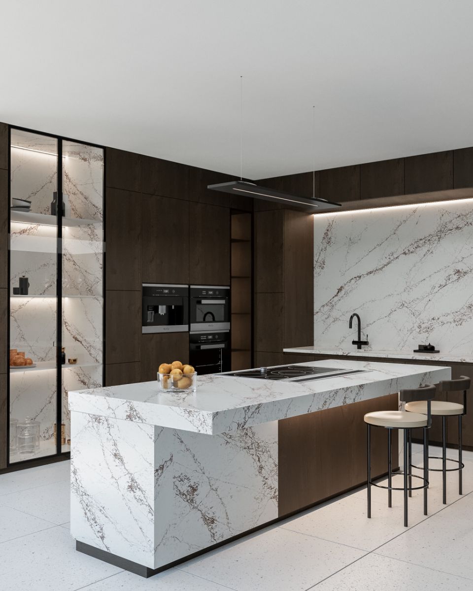 Minimalistická kuchyňa s tmavým dreveným dekorom, mramorovým obkladom a bielym ostrovom s barovými stoličkami.