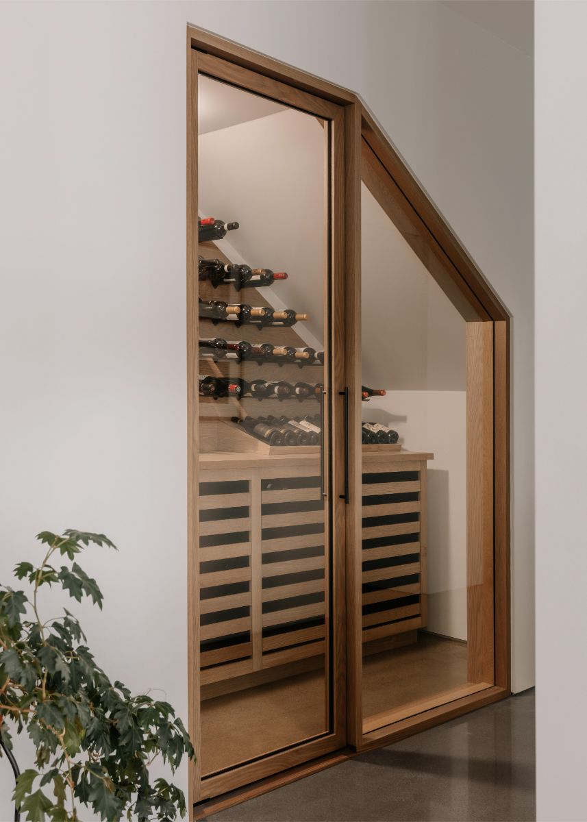 Členitý priestor je šikovne využitý ako vinotéka. Ako inak - na mieru robená z dreva.