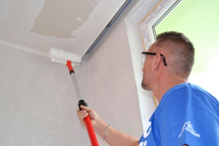 Muž pri nanášaní tmelu Rigips.