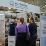 Ľudia pri stánku na Veľtrhu nehnuteľností.