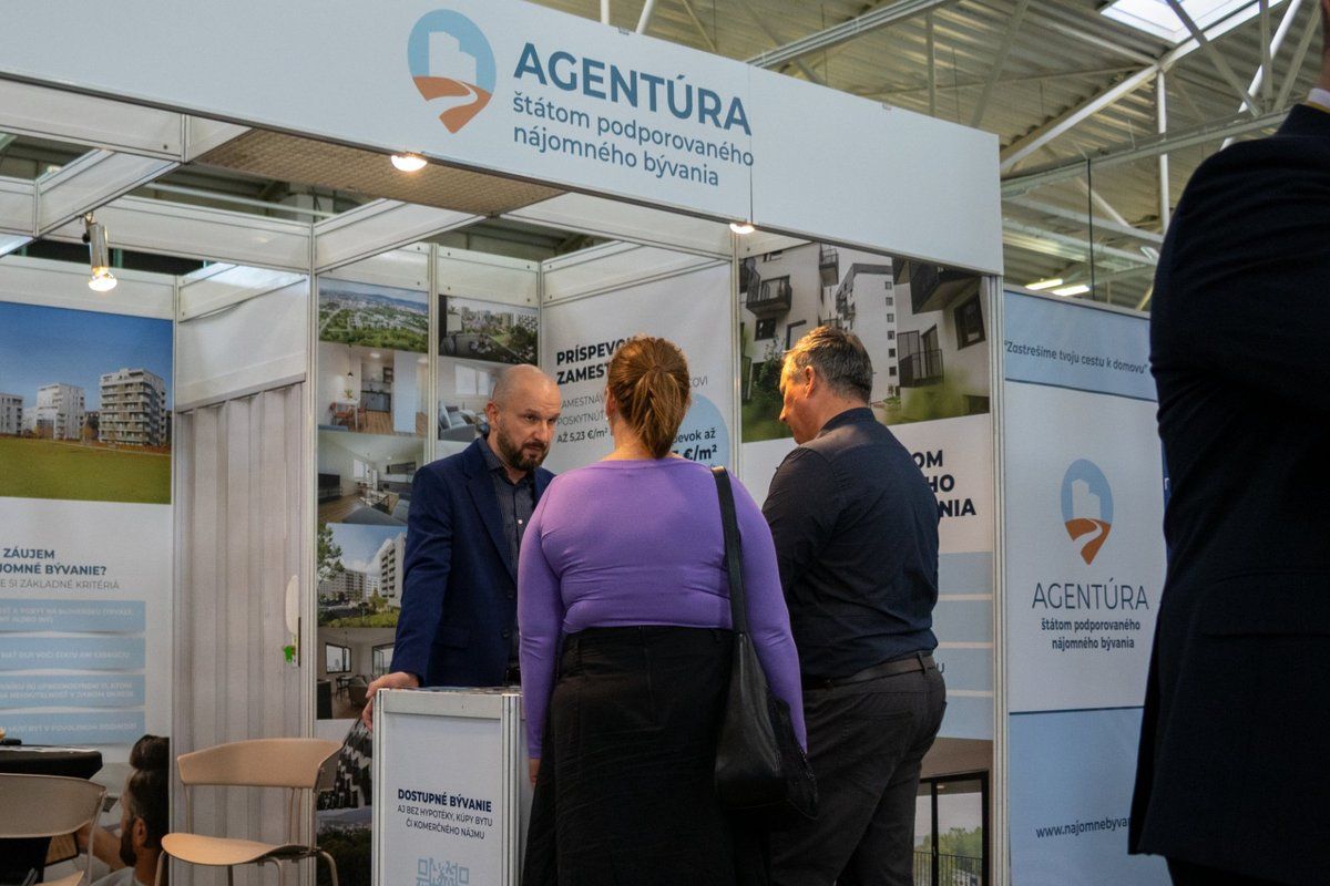 Ľudia pri stánku na Veľtrhu nehnuteľností.