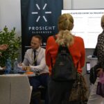 Ľudia pri stánku na Veľtrhu nehnuteľností.